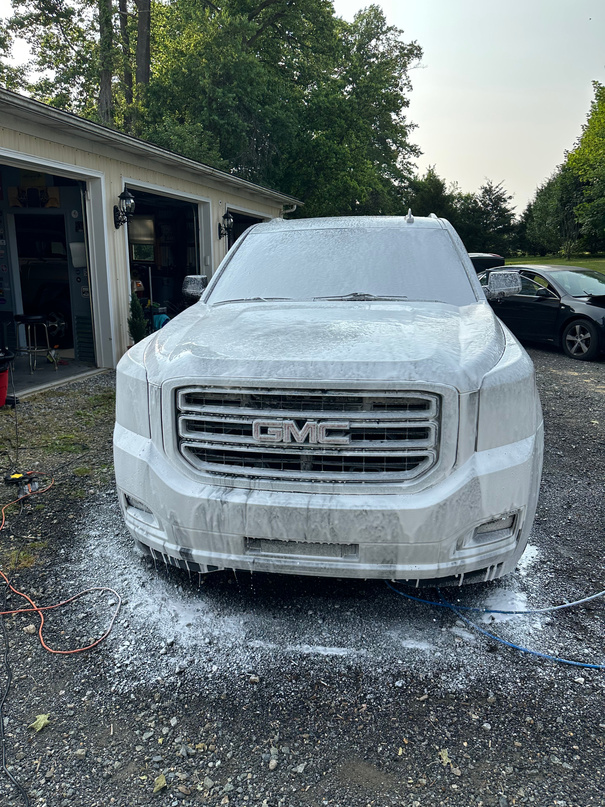 This GMC Yukon is receiving a pre-rinse foam bath.